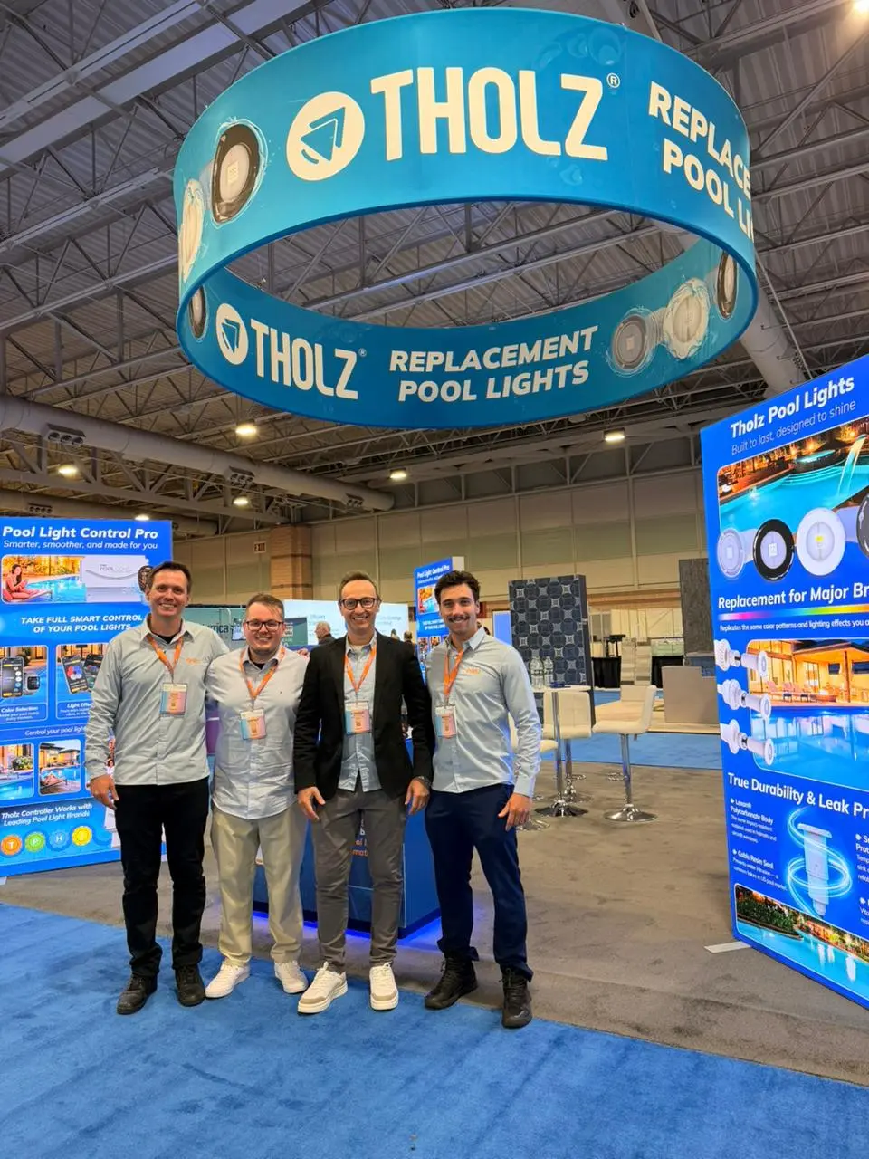 Tholz Global team standing at an international trade show booth showcasing replacement pool lights and smart pool lighting solutions.